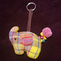 an elephant keychain with a pink pom - pom on it