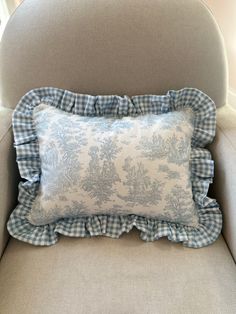 a blue and white pillow sitting on top of a chair