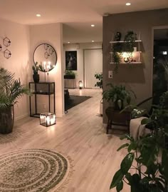 a living room filled with lots of plants next to a fire place and wall mounted clock