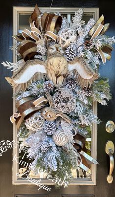 a christmas wreath hanging on the front door decorated with ribbons and feathers, snowflakes