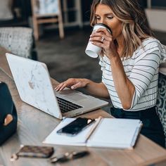 a woman drinking coffee while using her laptop