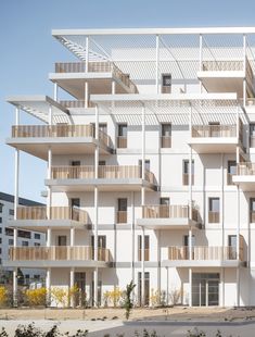 an apartment building with balconies and balconies on the second floor is white