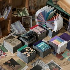 an assortment of cards and books on a table with other items in the room around them