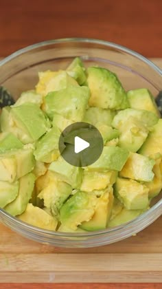 a glass bowl filled with sliced avocado on top of a wooden cutting board