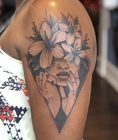 a woman's arm with flowers on it and her face in the middle of the arm