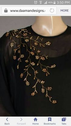 a black dress with gold embroidered flowers on it