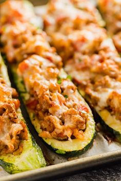 stuffed zucchini boats on a baking sheet with the title text above it reads italian stuffed zucchini boats