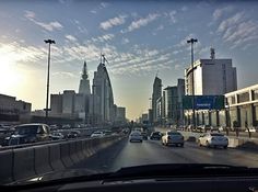 cars are driving down the highway in front of tall buildings and skyscrapers on either side