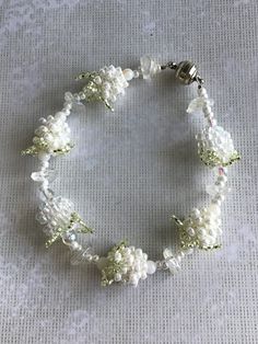 "This creamy whte version of the beaded berry bracelet came to me one morning I couldn't sleep.  The beaded berries are topped with pale green petals.  The bracelet is comprised of seed beads, glass leaves and 4mm rounds to compliment the berries.  It is strung on beading wire and closes with a magnetic clasp in silvertone.   A pretty summer piece for a summer or winter wedding accessory. A unique look.  A little bit country, vintage, shabby chic.  Totally original. Bracelet fits up to a 7\" wri Beaded Berries, Beaded Berry, Berry Bracelet, Winter Wedding Accessories, Beaded Bead, Country Vintage, Winter Jewelry, Purple Gift, Brick Stitch Earrings