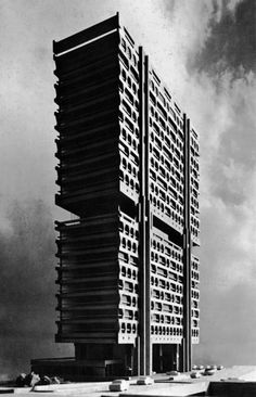 a tall building with many windows on the top and bottom floors, against a cloudy sky