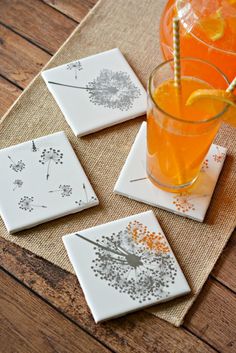 four coasters on a table with an orange drink