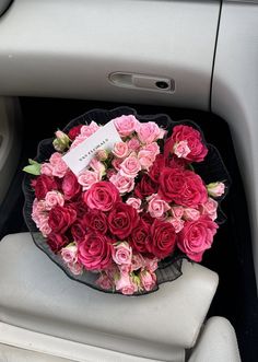 a bouquet of pink roses sitting in the center console of a car with a price tag on it