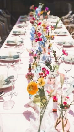 a long table with flowers and plates on it