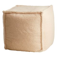 a white cube shaped ottoman with a thick, fluffy cover on it's sides