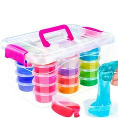 a plastic container filled with lots of different colored containers next to a hand holding an object