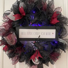 a wreath that says will trade candy for wine with red and black mesh around it