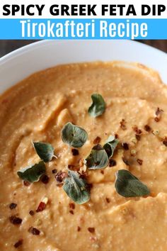 a white bowl filled with soup and garnished with green leaves on top, next to the words spicy greek feta dip