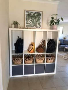 a white shelf filled with lots of purses and shoes