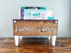 a wooden sign that says lincoln's library on it sitting on a wood table