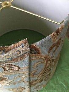 a close up of an umbrella on a green cloth covered table with a gold handle