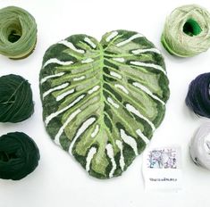 the yarns are laid out on the table to make a monster leaf decoration