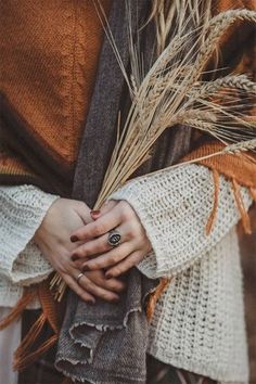 a person with their hands wrapped around each other and holding some grass in front of them