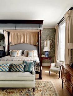 a bedroom with a four poster bed and lots of pillows