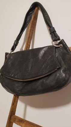 a black purse sitting on top of a wooden chair