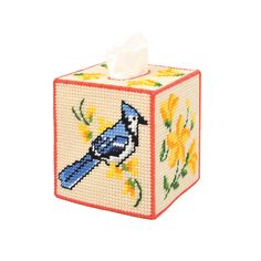 a tissue box with a blue bird on it and yellow flowers around the edges is shown