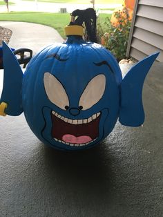 a blue pumpkin with an angry face on it's side and ears sticking out