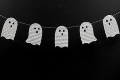 paper ghost buntings are hanging on a string with black and white pages in the background