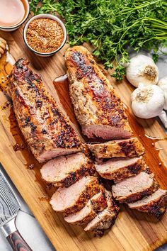 sliced pork on a cutting board with garlic, parsley and seasoning next to it