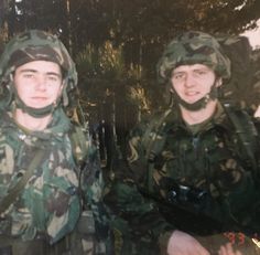 two men in camouflage uniforms standing next to each other