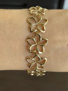 Elegant And Beautiful Hawaiian 14K Solid Yellow Gold 18mm Plumeria Flower Lei Bracelet 7 1/2 Inches High Polished Finish 14 Karat Solid Yellow Gold GUARANTEED, Authenticated with a 14K Stamp Made With Highest Quality Craftsmanship Solid 14K Yellow Gold Plumeria Flower Lei Bracelet Length 7.5 Inches Total Weight 11.8 grams Solid 14K Yellow Gold Plumeria Flower Width 18 Millimeters Amazing Gift For Family And Friends! Jewelry Gift Box Included! Flower Shaped Anniversary Bracelets, Anniversary Bracelets With Flower Charm, Yellow Gold Plated Flower Jewelry, Gold Flower-shaped Jeweled Jewelry, Hispanic Jewelry, Gold Flower Jewelry, Elegant Gold Flower-shaped Bracelets, Gold Hawaiian Bracelet, Gold Flower Bracelet