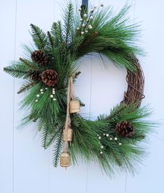 a christmas wreath with pine cones and bells