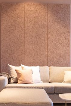 a living room with a couch, ottoman and coffee table in front of a wall