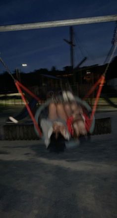 two people are laying in hammocks on the ground at night, with one person upside down