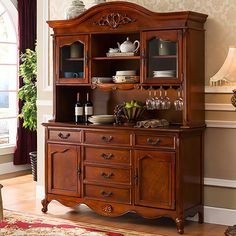 a dining room hutch with wine glasses on it