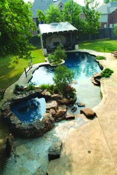 an outdoor swimming pool surrounded by landscaping