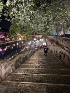 people are walking up and down the stairs at night time, with lights on them