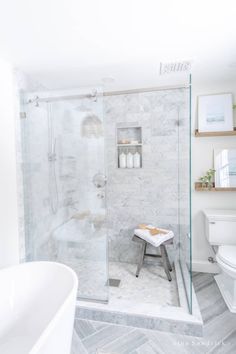 a bathroom with a white toilet and a walk in shower next to a bathtub