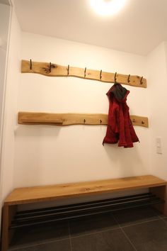 a wooden bench sitting next to a wall mounted coat rack