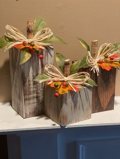 three small wooden boxes decorated with fall leaves