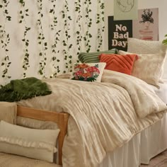 a bed with pillows and blankets on it in front of a wall covered with vines