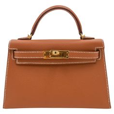 Brand: Hermès Style: Kelly II Sellier Mini Size: 20cm Color: Gold Material: Epsom Leather Hardware: Gold Hardware(GHW) Dimensions: 7.5" W x 4.5" H x 2.25" D Handle Drop: 3.25" Strap Drop: 18.5" Hermes Kelly 25, Mini Kelly, Vintage Kelly, Hermes Style, Brown Leather Satchel, Luxury Jewelry Brands, Kelly Bag, Vintage Hermes, Hermes Bags