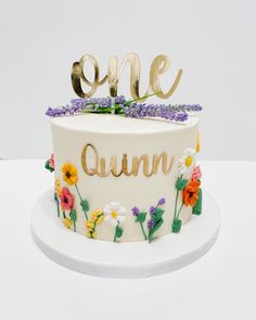 a cake decorated with flowers and the word'one '