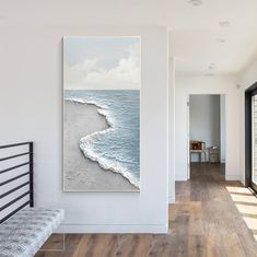 a painting hanging on the wall next to a bed in a room with hardwood floors