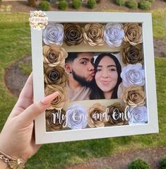 a person holding up a photo frame with flowers on it