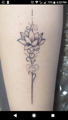 a tattoo with a flower on the side of her leg and an arrow in the middle