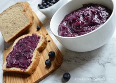 a bowl of blueberry sauce next to two slices of bread